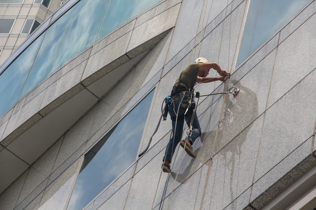 Cleaner on ropes washing a building façade