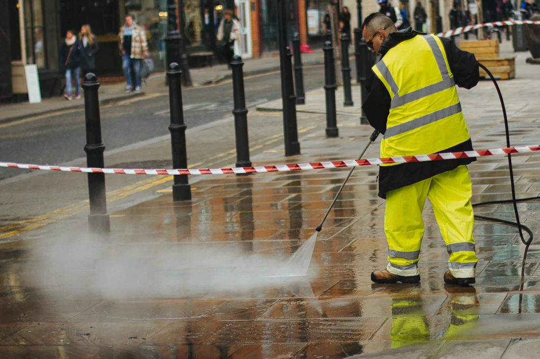 Worker pressure-washing outdoor paving